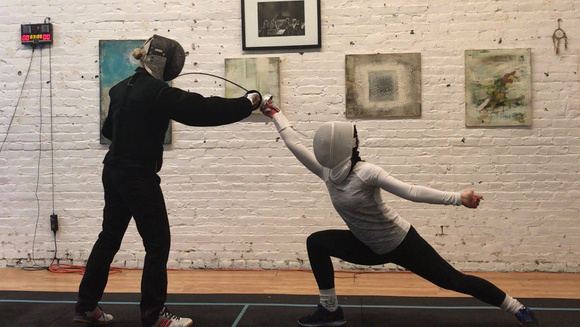 Dorina coaching fencing, mid-lunge